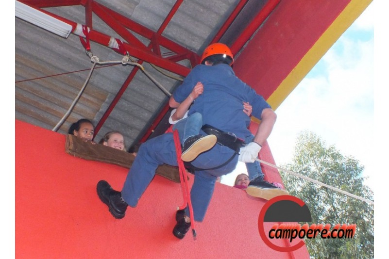 Crianças e adolescentes visitam e participam de atividades com bombeiros.